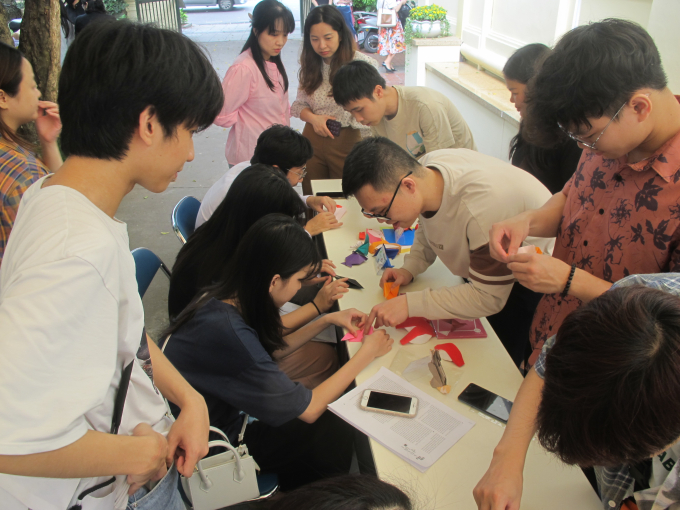 Khách tham quan triển lãm thích thú tham gia trò chơi gấp giấy Origami.