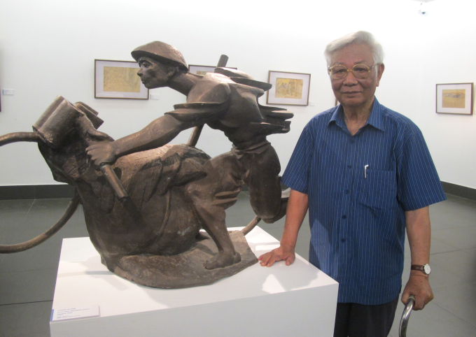 Nhà điêu khắc Lưu Danh Thanh bên tác phẩm “Cả nước ra trận” của ông. Ảnh: L.Q.V