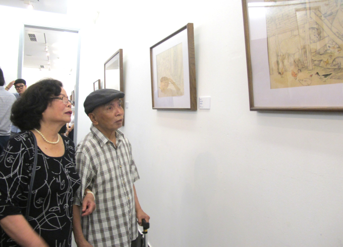 Vợ, chồng họa sĩ Tô Ngọc Thành (con trai của họa sĩ Tô Ngọc Vân) xem chùm ký họa của người cha tại Điện Biên. Ảnh: L.Q.V 