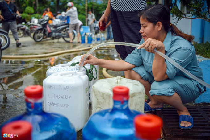 Tại khu dân cư thuộc phường Hạ Đình, gần nhà máy Rạng Đông tận dụng can vốn để chứa rượu ra hứng nước.