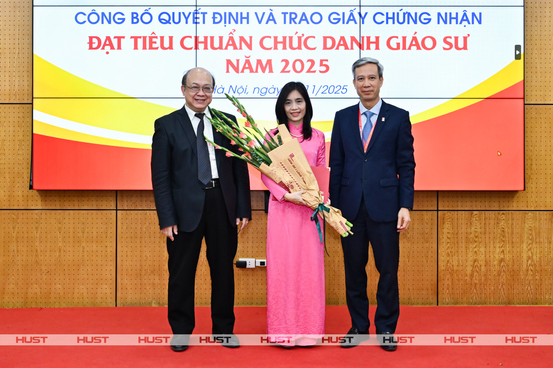 PGS. Huỳnh Quyết Thắng - Giám đốc Đại học Bách Khoa Hà Nội và GS. Lê Anh Tuấn - Bí thư Đảng ủy, Chủ tịch HĐĐH ĐHBK Hà Nội trao Giấy Chứng nhận đạt tiêu chuẩn chức danh Giáo sư và tặng hoa chúc mừng nhà giáo Huỳnh Thị Thanh Bình