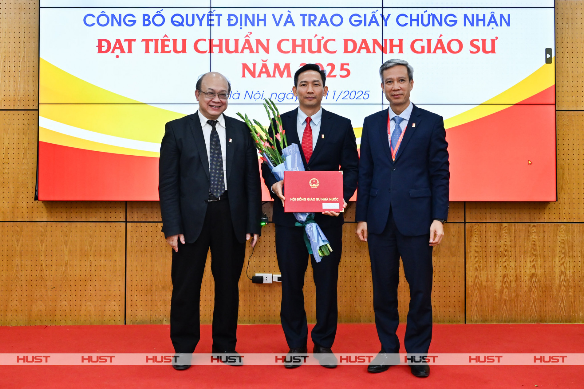 PGS. Huỳnh Quyết Thắng - Giám đốc Đại học Bách khoa Hà Nội và GS. Lê Anh Tuấn - Bí thư Đảng ủy, Chủ tịch HĐĐH ĐHBK Hà Nội trao Giấy Chứng nhận đạt tiêu chuẩn chức danh Giáo sư và tặng hoa chúc mừng nhà giáo Phạm Văn Sáng