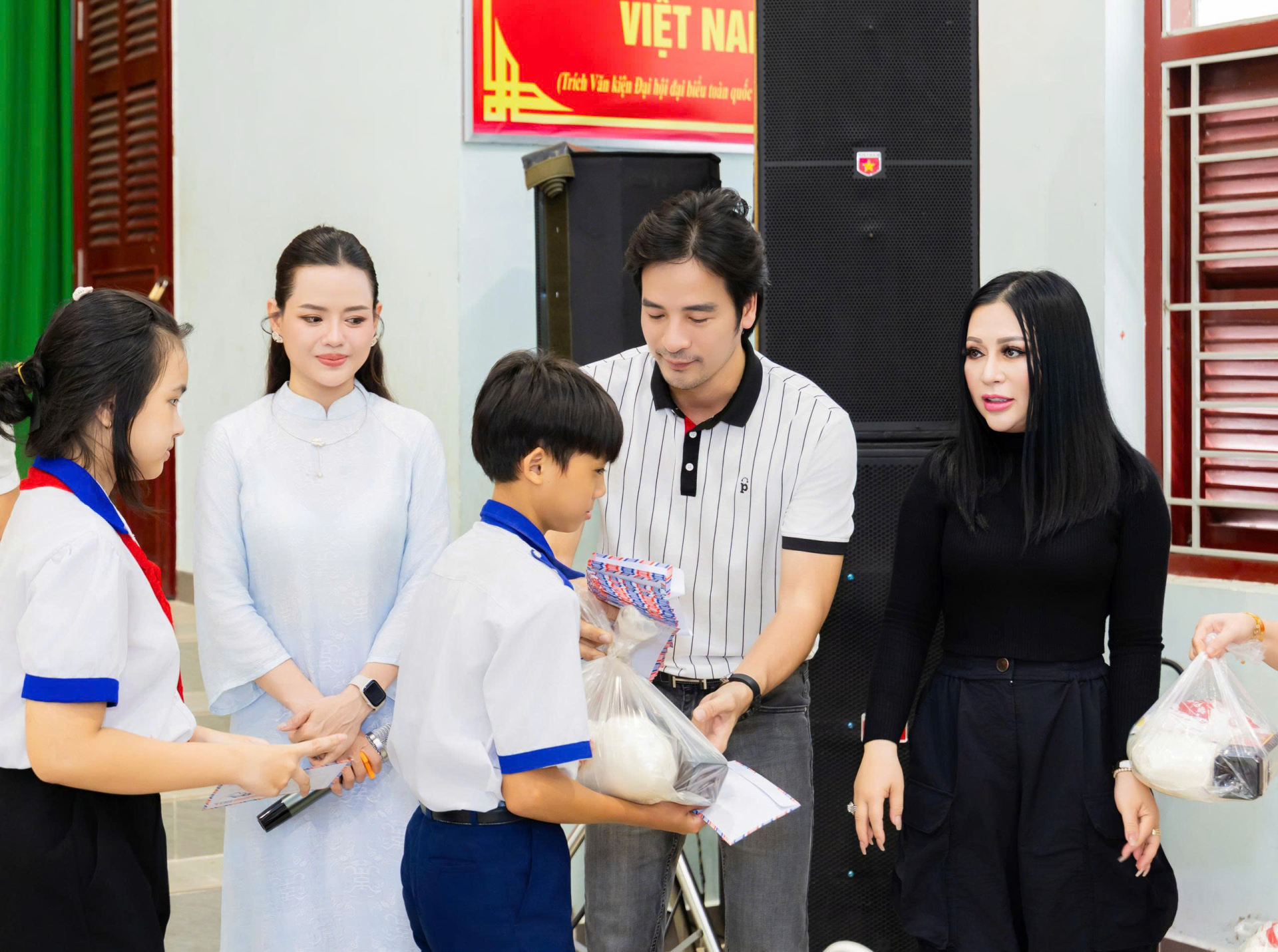 Nghệ sĩ Kristine Thảo Lâm và Đoàn Minh Tài trao tận tay những món quà yêu thương tân tay các học sinh nghèo. Ảnh: Phi Võ