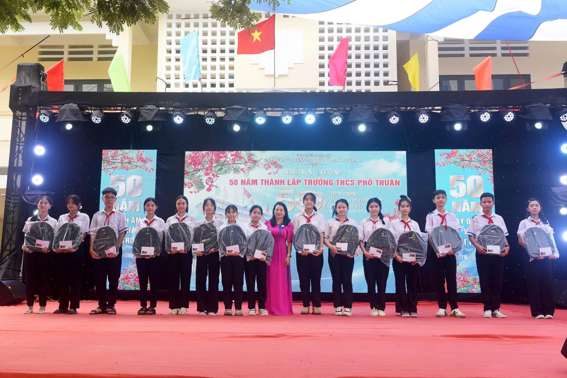 Hiệu trưởng và Phó hiệu trưởng nhà trường trao học bổng và quà cho các em học sinh nghèo hiếu học.