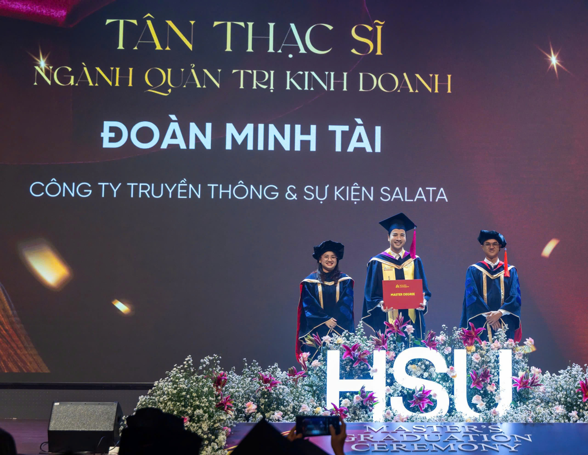 Đoàn Minh Tài trên sân khấu giảng đường nhận bằng tốt nghiệp MBA.