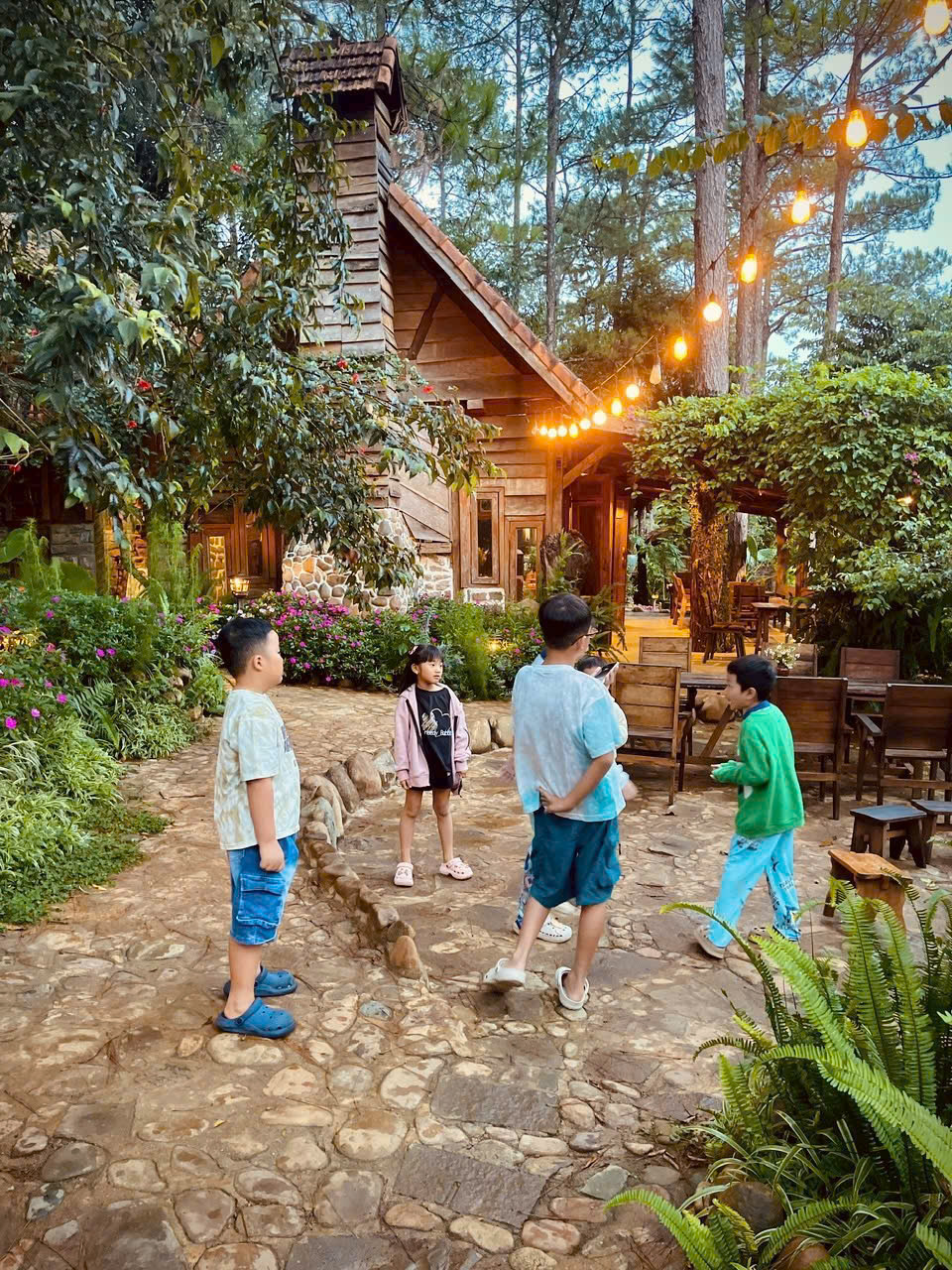 Ánh đèn vàng, những căn nhà gỗ và khu vườn xanh tạo nên khung cảnh ấm cúng khi màn đêm buông xuống.