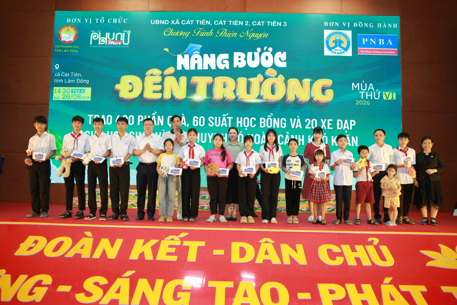 Nhà báo Phạm Ngọc Toại (thứ 6 từ trái sang), Phó trưởng Văn phòng đại diện Tạp chí Phụ nữ Mới tại TP.HCM, cùng các mạnh thường quân trao học bổng tiếp sức học sinh trên hành trình đến trường.