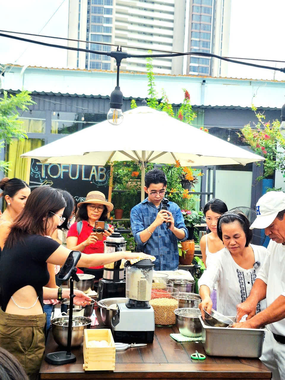 Khách tham dự trải nghiệm làm đậu hũ từ đậu nành hữu cơ tại chương trình