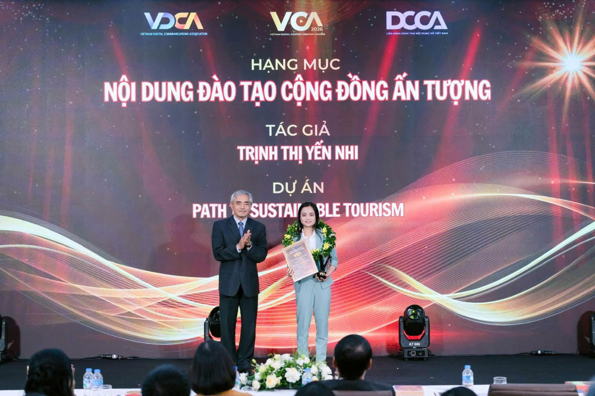 Chủ tịch Nguyễn Minh Hồng trao giải cho chị Trịnh Thị Yến Nhi tại Lễ trao Giải thưởng Sáng tạo Nội dung số Việt Nam 2026, ngày 26/8 tại Hà Nội. Ảnh: VCA.