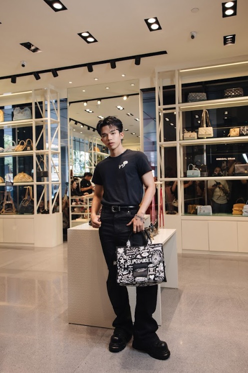   Lezii - thành viên nhóm FIRSTGENE - khéo hack chiều cao với giày derby chunky và trang phục all black tối giản làm nền cho túi xách Tote Bag.  