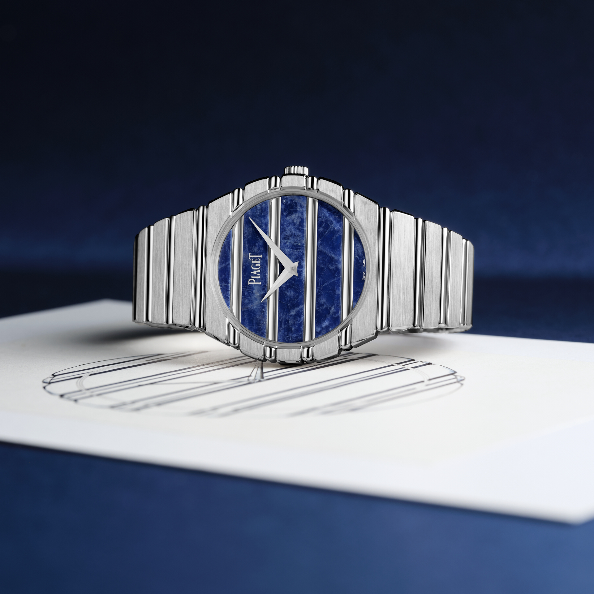   Điểm nhấn khác biệt của Piaget Polo 79 nằm ở cấu trúc nguyên khối xẻ rãnh, vừa đậm chất thể thao nhưng lại mềm mại như một chiếc vòng trang sức. Thiết kế được chế tác từ vàng trắng 18K, xóa nhòa ranh giới giữa bộ vỏ và dây đeo bằng các đường khía nổi chạy liên tục, tạo hiệu ứng thị giác dập dìu tựa những nhịp sóng trải dài vô tận.   