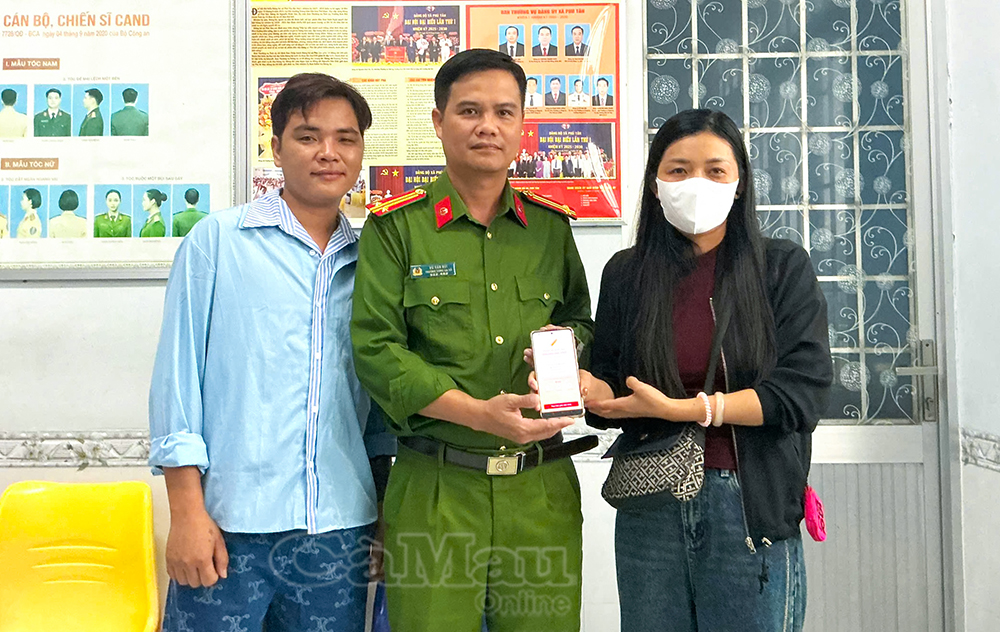 Chị Lữ Mai Linh chuyển khoản trao trả 200 triệu đồng chuyển nhầm cho anh Nguyễn Chí Nguyện, tại trụ sở Công an xã Phú Tân.
