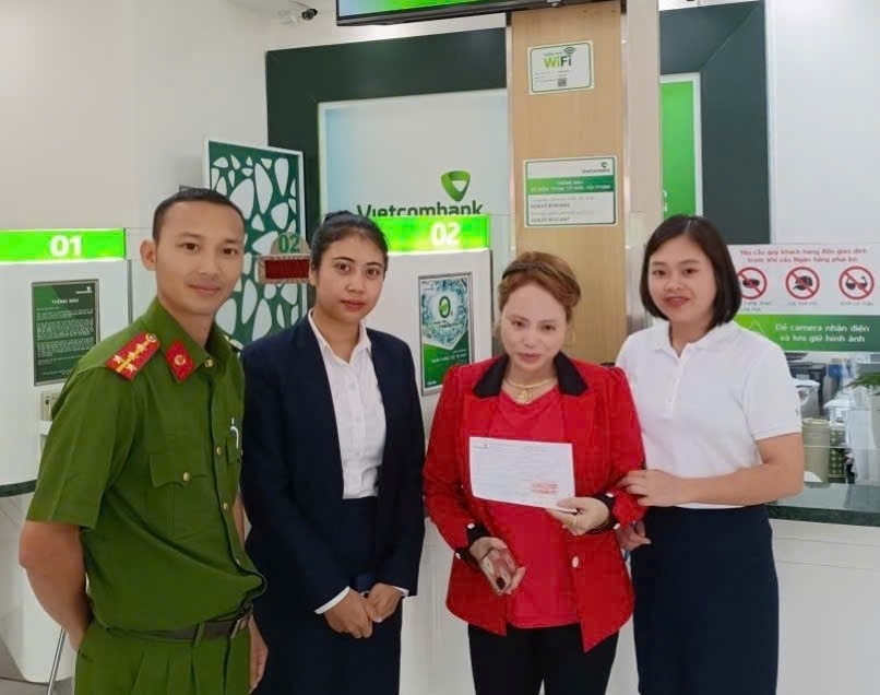 Công an phường phối hợp với nhân viên ngân hàng hỗ trợ chị Lê Thị Sâm chuyển trả số tiền cho anh Nguyễn Thành Long do chuyển khoản nhầm.