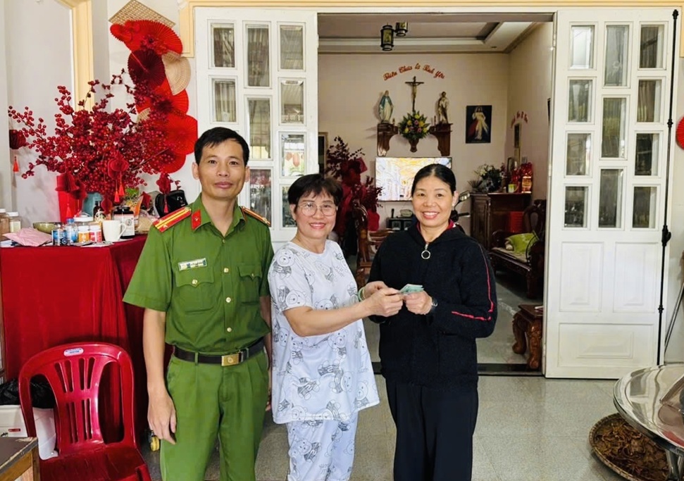 Đồng chí Hà Văn Kiên hỗ trợ bà Vũ Thị Minh Phượng nhận lại tiền chuyển khoản nhầm. Ảnh: Công an tỉnh Lâm Đồng.