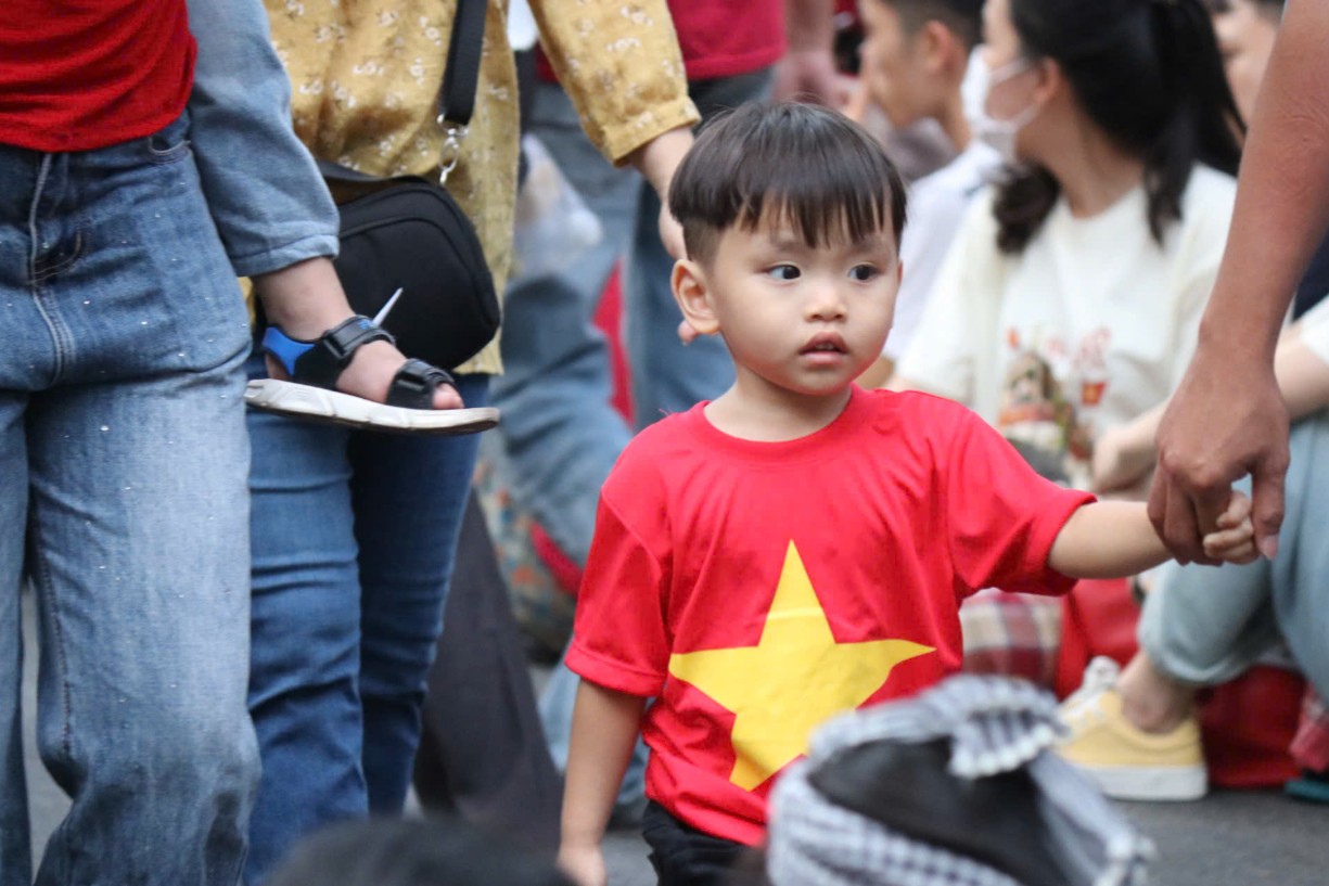 Em bé cùng cha mẹ tham dự và cảm nhận sự kiện lớn của đất nước - Ảnh: NLĐ