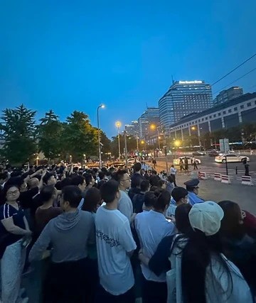 Đám đông hiếu kỳ túc trực bên ngoài khách sạn.
