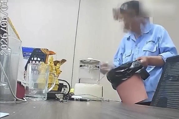Người đàn ông trong đồng phục nhân viên vệ sinh đổ thẳng nước từ thùng rác vào bình nước uống của đồng nghiệp.