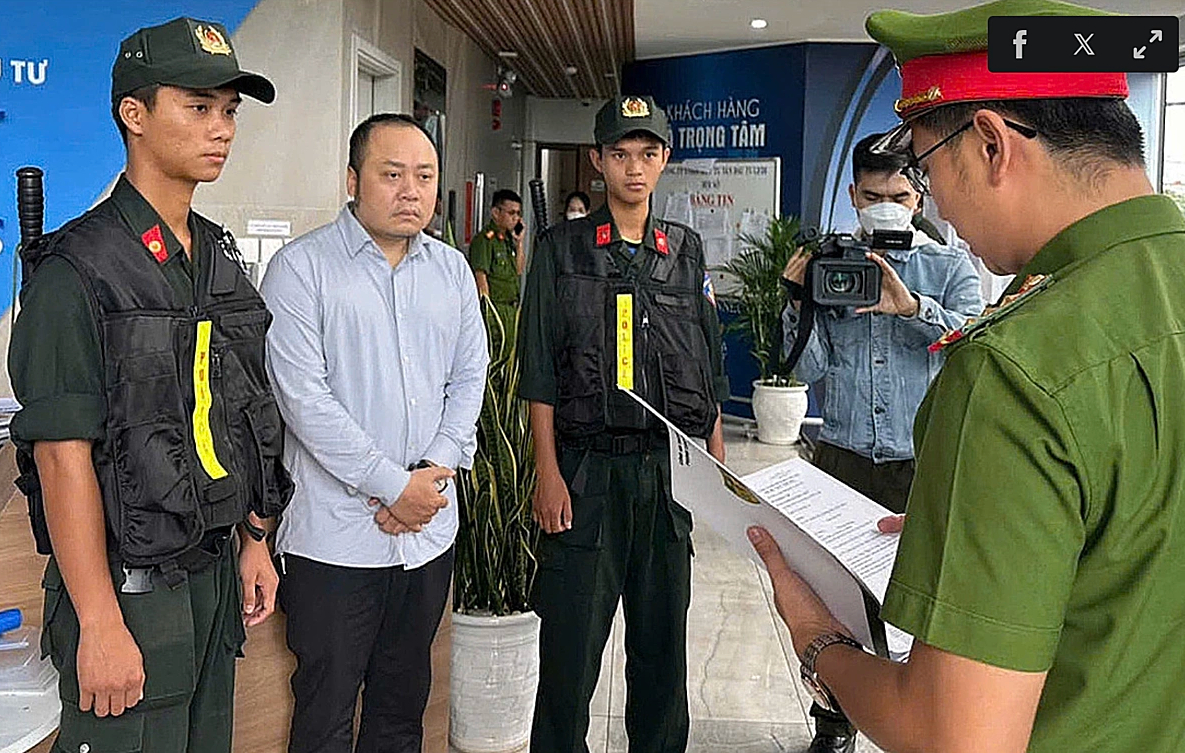 Nguyễn Quang Hoàng nghe đọc lệnh khám xét nơi ở, ngày 8/11 (Ảnh:CAND)