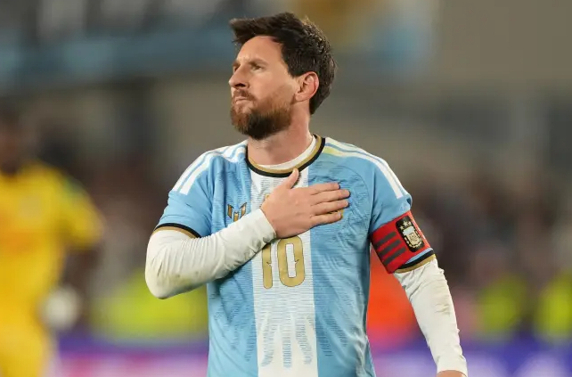 Lionel Messi chạm vào huy hiệu đội tuyển Argentina trong trận đấu chia tay, khép lại hơn 20 năm khoác áo đội tuyển quốc gia (Nguồn: Marca)