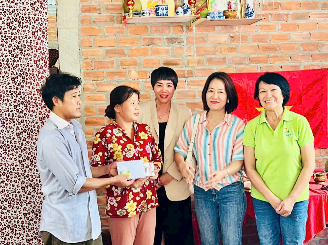 Helen Nguyễn (áo vest màu bè) trong ngôi nhà mà cô và những người bạn cùng góp tiền xây dựng cho người nghèo ở miền Tây.