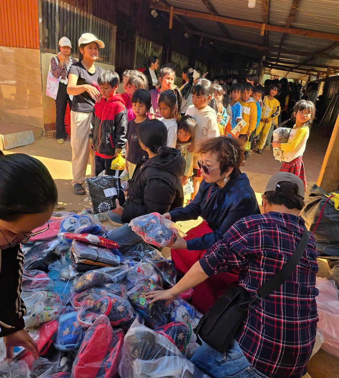 Nghệ sĩ Đức Xuân phân quà, trực tiếp tận tay gửi tặng đến bà con và học sinh nghèo.