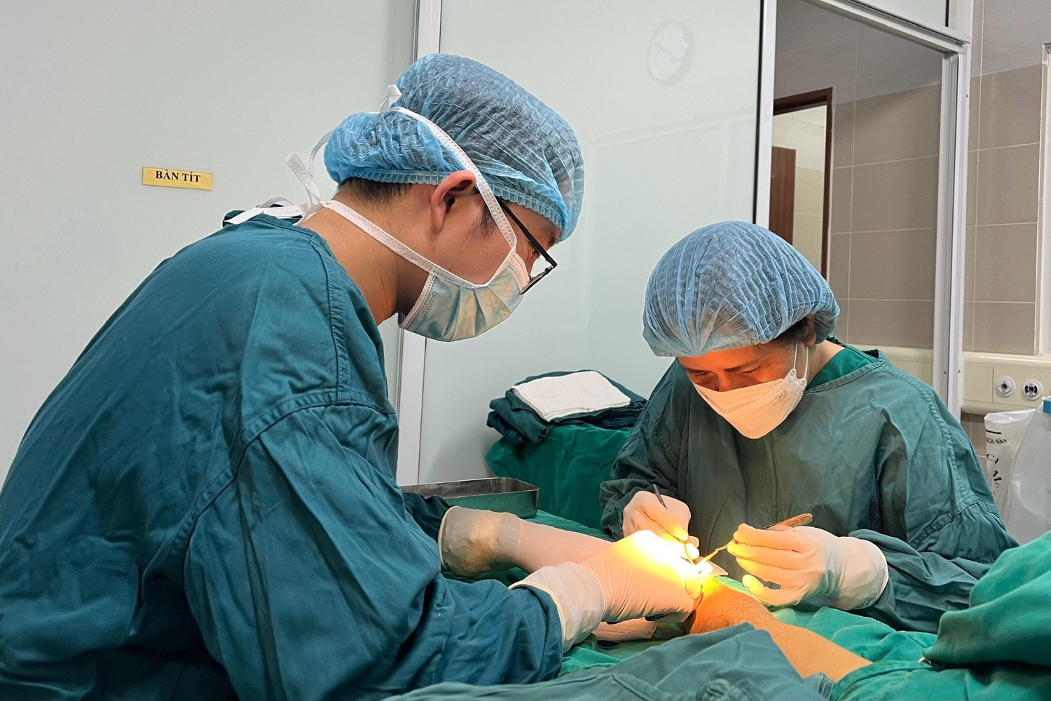 PGS.TS Phạm Thị Việt Dung thực hiện một ca vi phẫu kéo dài nhiều giờ tại Bệnh viện Bạch Mai. Với kính hiển vi phẫu thuật và từng thao tác chính xác đến từng mạch máu nhỏ, chị và ê-kíp đã cứu nhiều trường hợp đứng trước nguy cơ mất chi hoặc biến dạng nặng.