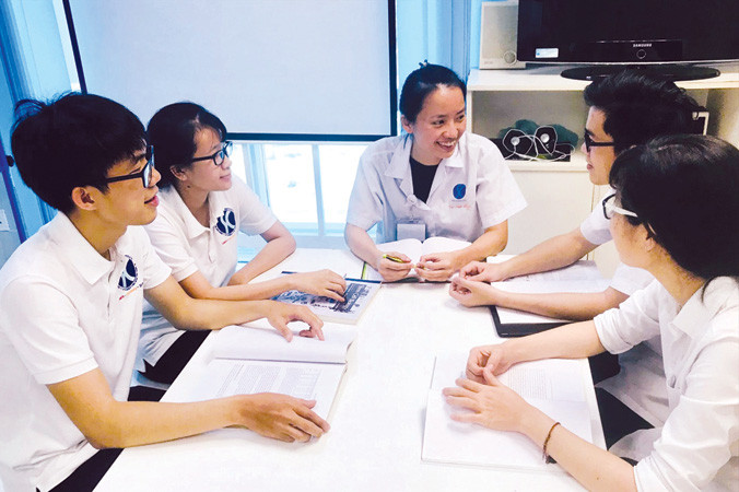 PGS.TS Vũ Bích Ngọc trao đổi chuyên môn với đồng nghiệp và nghiên cứu sinh tại phòng thí nghiệm tế bào gốc.