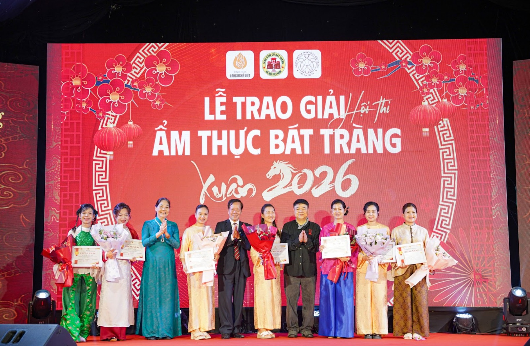 Nghệ nhân ẩm thực Hà Thị Vinh (áo dài xanh), chủ tịch Hiệp hội UNESCO Hà Nội Trương Minh Tiến (áo vest) và Chuyên gia ẩm thực, Chủ tịch Hiệp hội Dạy nghề và Việc làm Đầu bếp Việt Nam, Trưởng Ban Giám khảo Nguyễn Thường Quân trao giải cho đội thi mâm cỗ giỗ tổ tối ngày 3/4, Ảnh: Văn Giang.