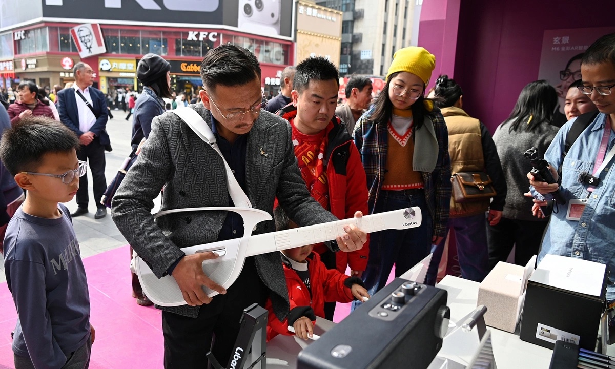 Một người thử đàn LiberLive C1 tại sự kiện ở Thành Đô, tỉnh Tứ Xuyên, ngày 14/2. Ảnh: VCG