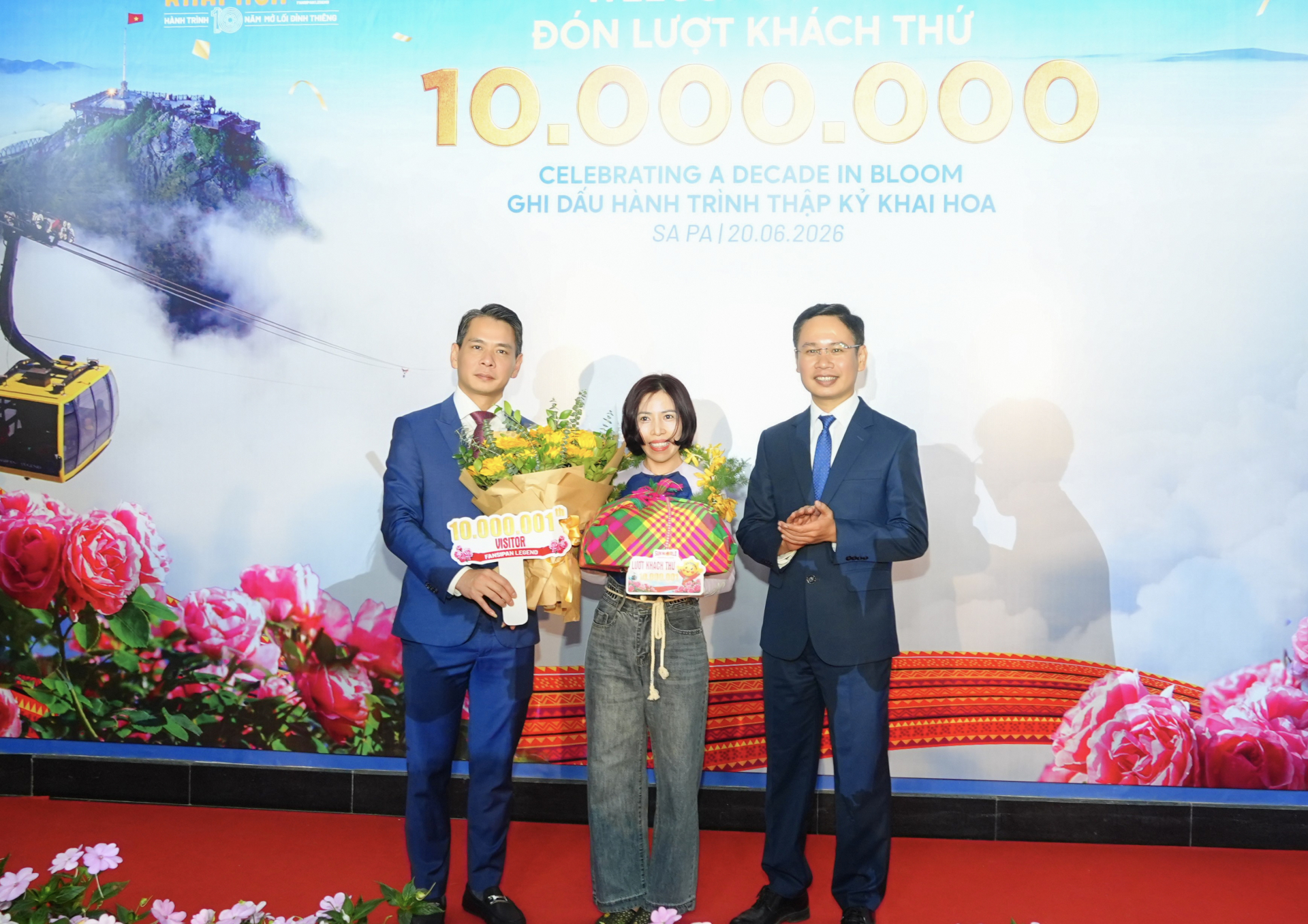 Ông Đặng Việt Dũng, Ủy viên Ban Thường vụ Đảng ủy phường, Phó Chủ tịch Thường trực UBND phường Sa Pa (bên trái) trao quà cho vị khách 10.000.001.