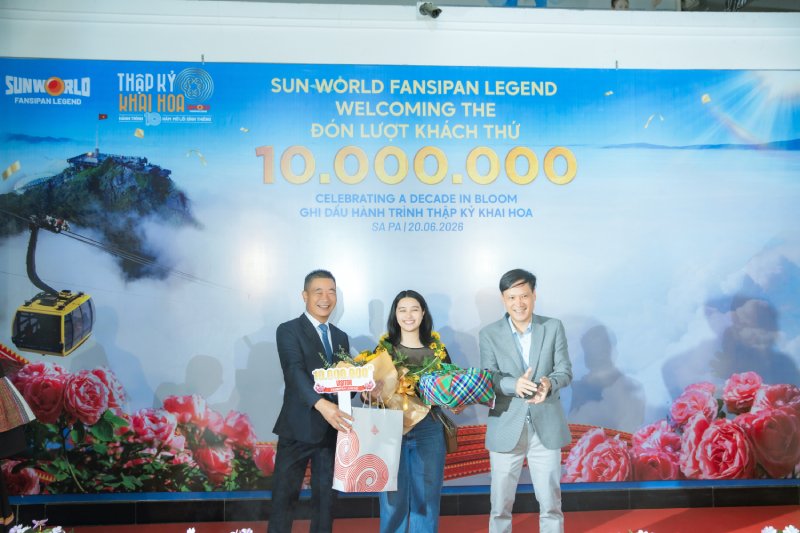 Ông Phạm Cao Vỹ - Chủ tịch Hiệp hội Du lịch tỉnh Lào Cai (bên trái) trao quà tặng cho vị khách thứ 10 triệu.