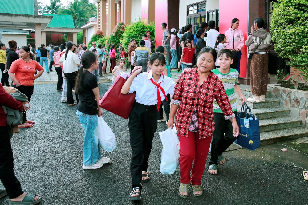 Học sinh và phụ huynh vui vẻ mang quà về.