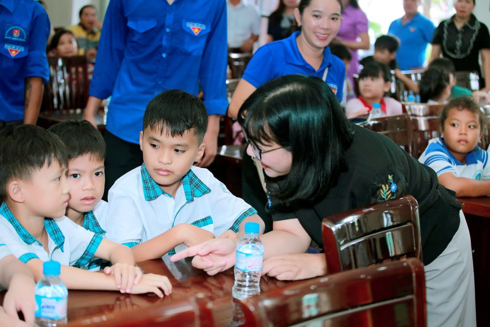 Nhà báo Chu Thị Thu Hằng, Tổng Biên tập Tạp chí Phụ nữ Mới hỏi thăm các bé được nhận quà tại chương.