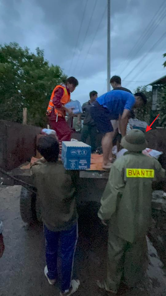 Bảo Duy (dấu mũi tên đỏ) đang cùng mọi người đưa lương thực, nước uống cho người dân 