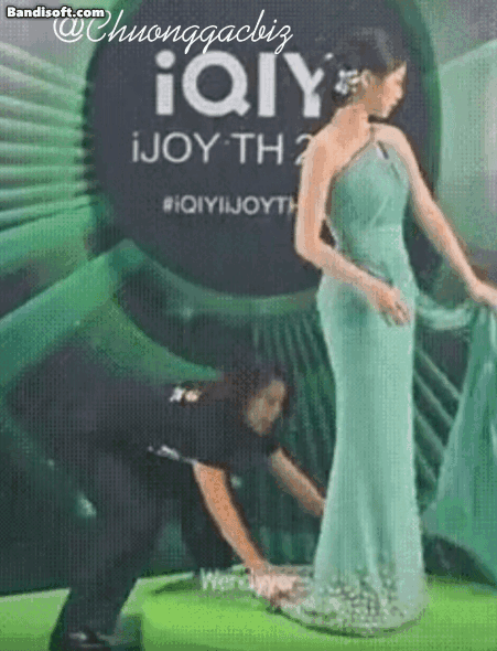 Ngu Thư Hân được một nhân viên chỉnh trang phục giúp, thế nhưng cô lại hất tà váy vào mặt người này