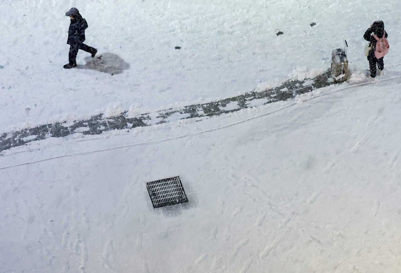 Vệt hành lý hiện rõ trên đường phố Seoul khi thành phố chứng kiến trận tuyết rơi đầu tiên trong mùa đông năm nay.