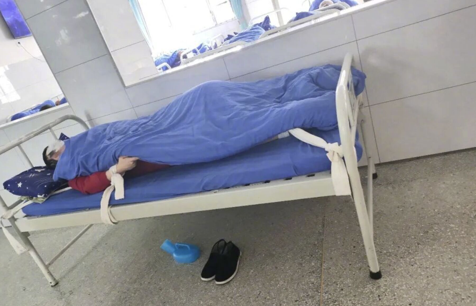 Một bệnh nhân bị trói vào giường sau khi cãi nhau với nhân viên y tế.  (Ảnh: The Beijing News)