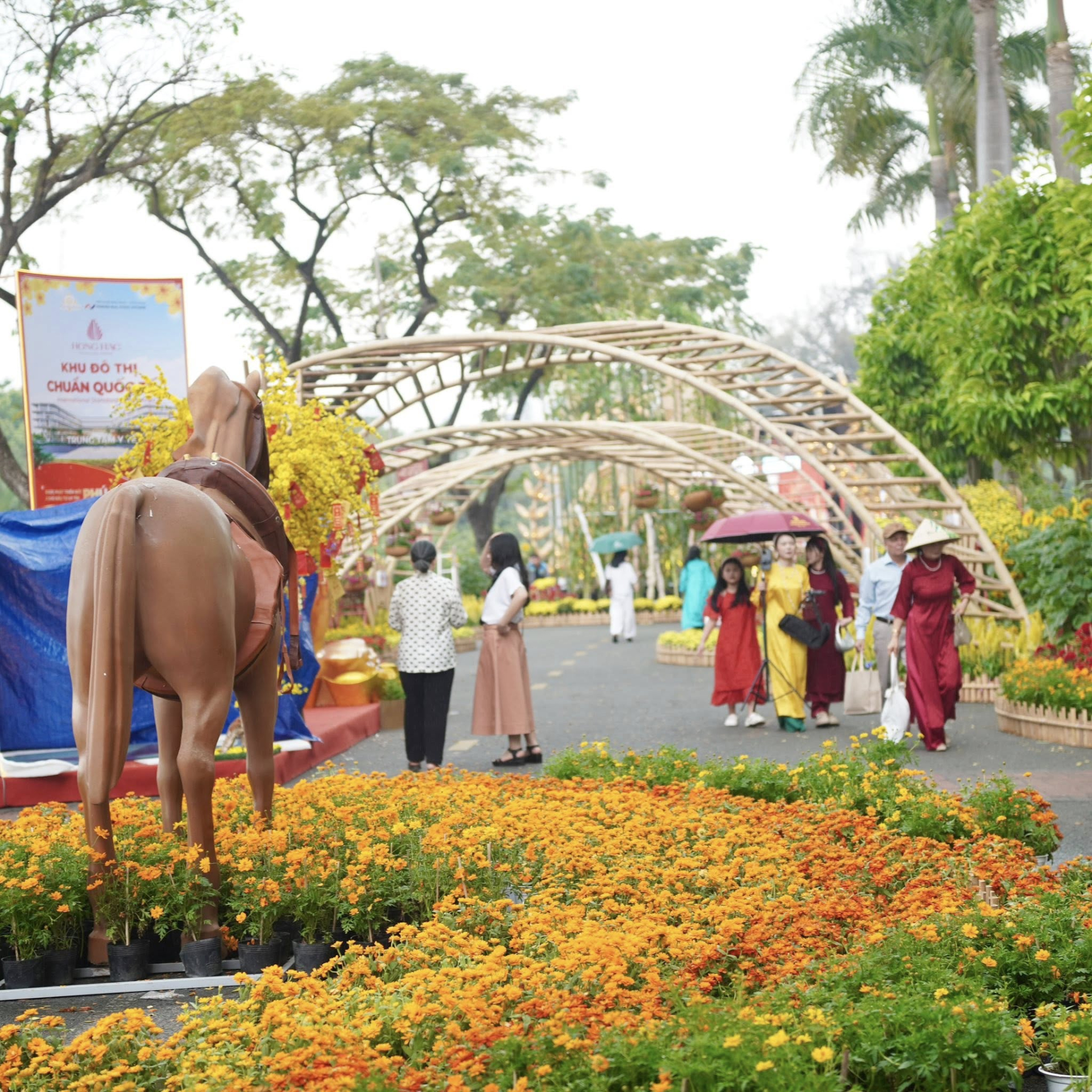   Nhiều du khách xúng xính áo dài chụp ảnh tại đường hoa Phú Mỹ Hưng. Ảnh: Đi Cùng Phúc  