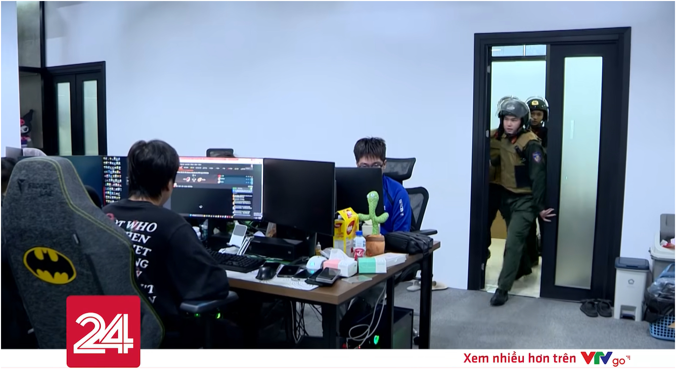 Khoảnh khắc Công an ập vào “tóm gọn” team Xôi Lạc TV, nhiều nhân viên đang ngồi trước dàn máy tính. Ảnh chụp màn hình.