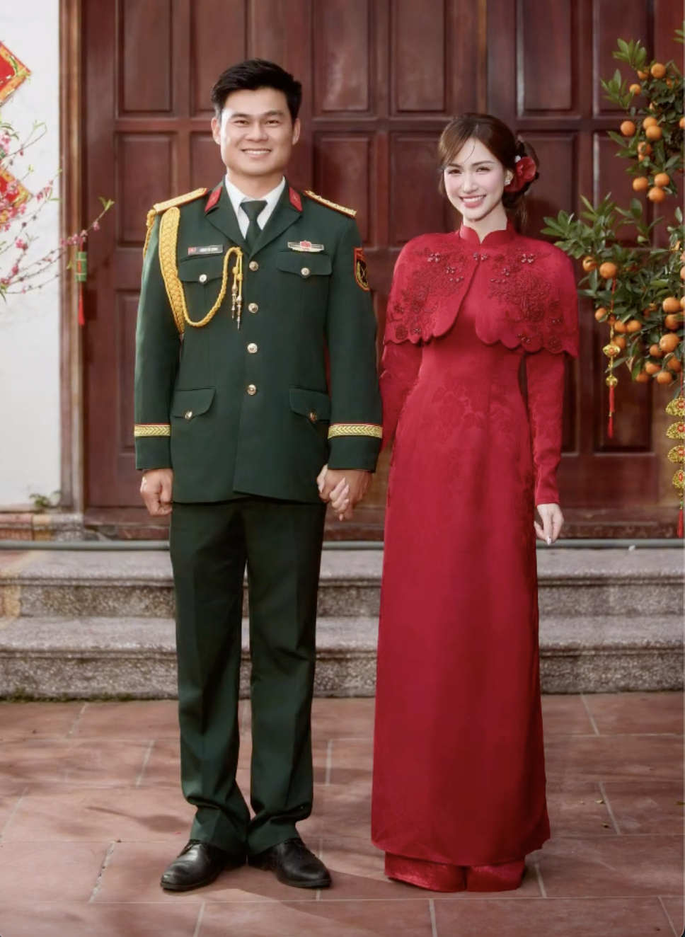 Tối 6/3, hình ảnh Hòa Minzy diện áo dài đỏ, nắm tay một chàng trai mặc quân phục. Ảnh: FBNV