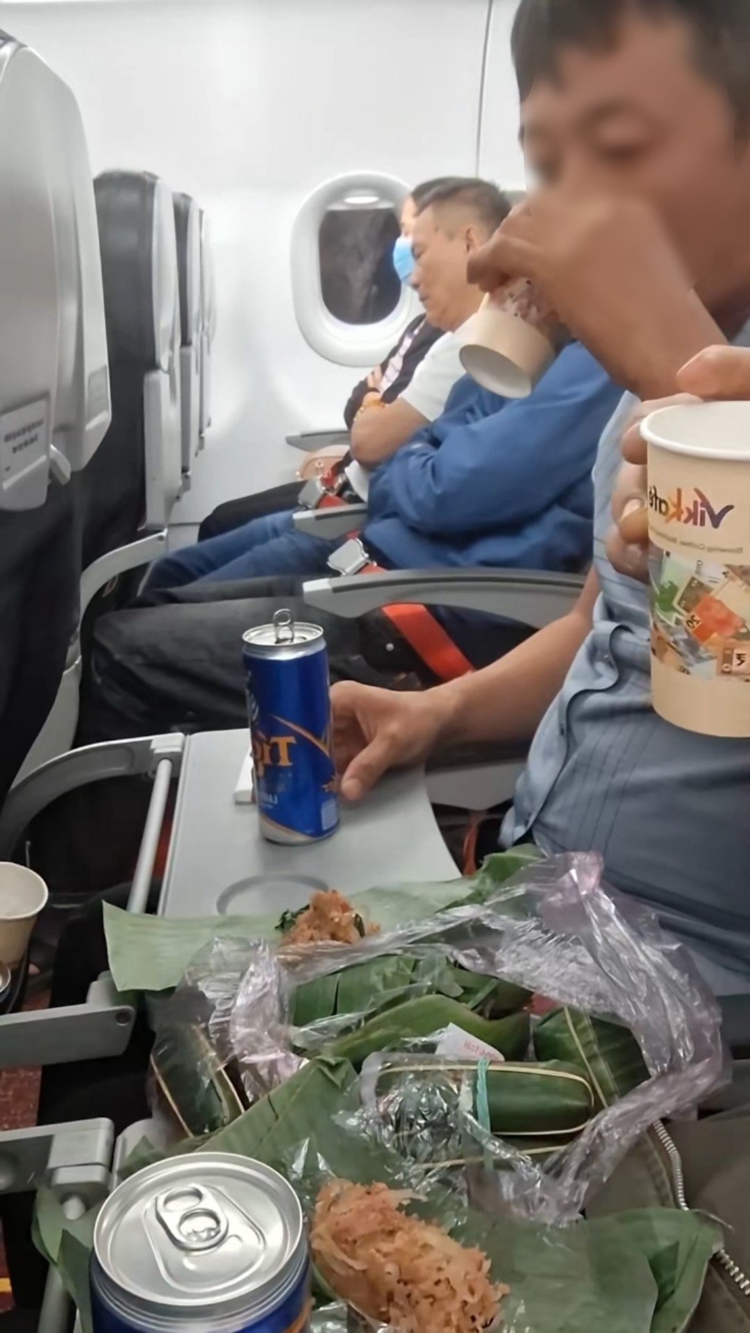 Mang cả túi nem chua, khui bia nhậu ngay trên máy bay, 2 người đàn ông gây tranh cãi dữ dội