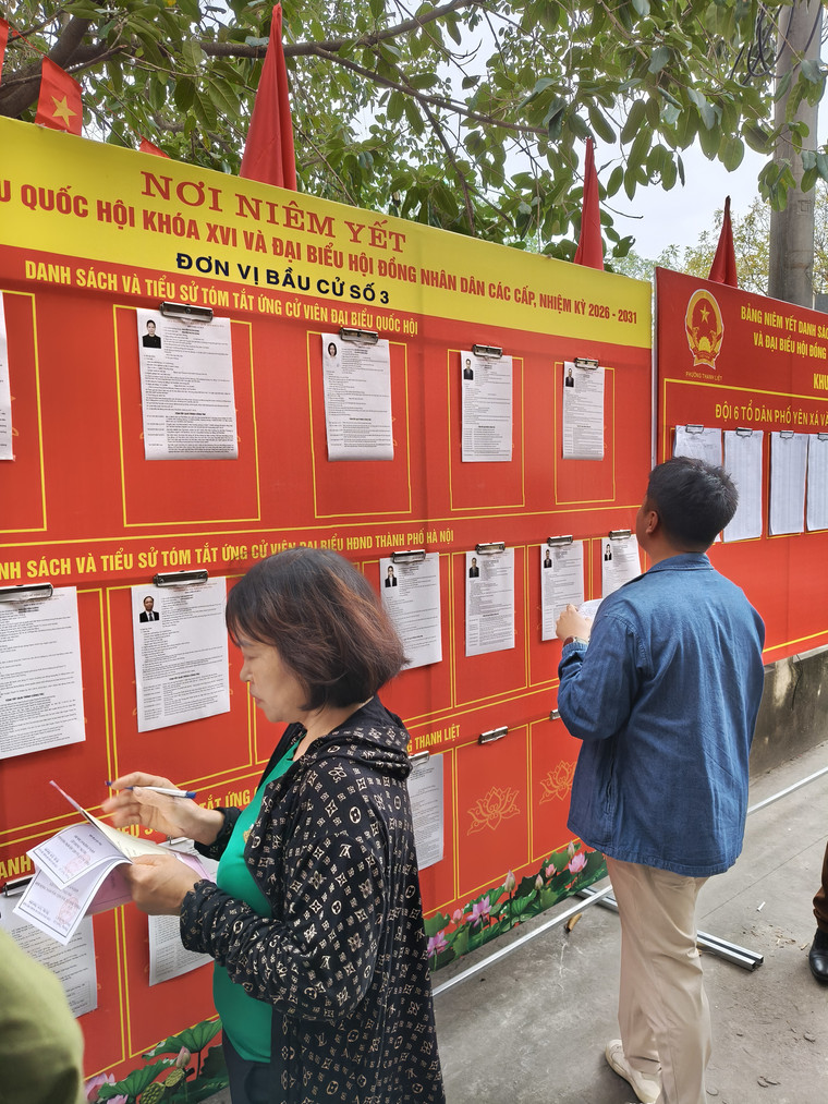 Tại địa điểm bỏ phiếu, Việt Thắng chăm chú xem lại danh sách các ứng cử viên Đại biểu Quốc Hội.