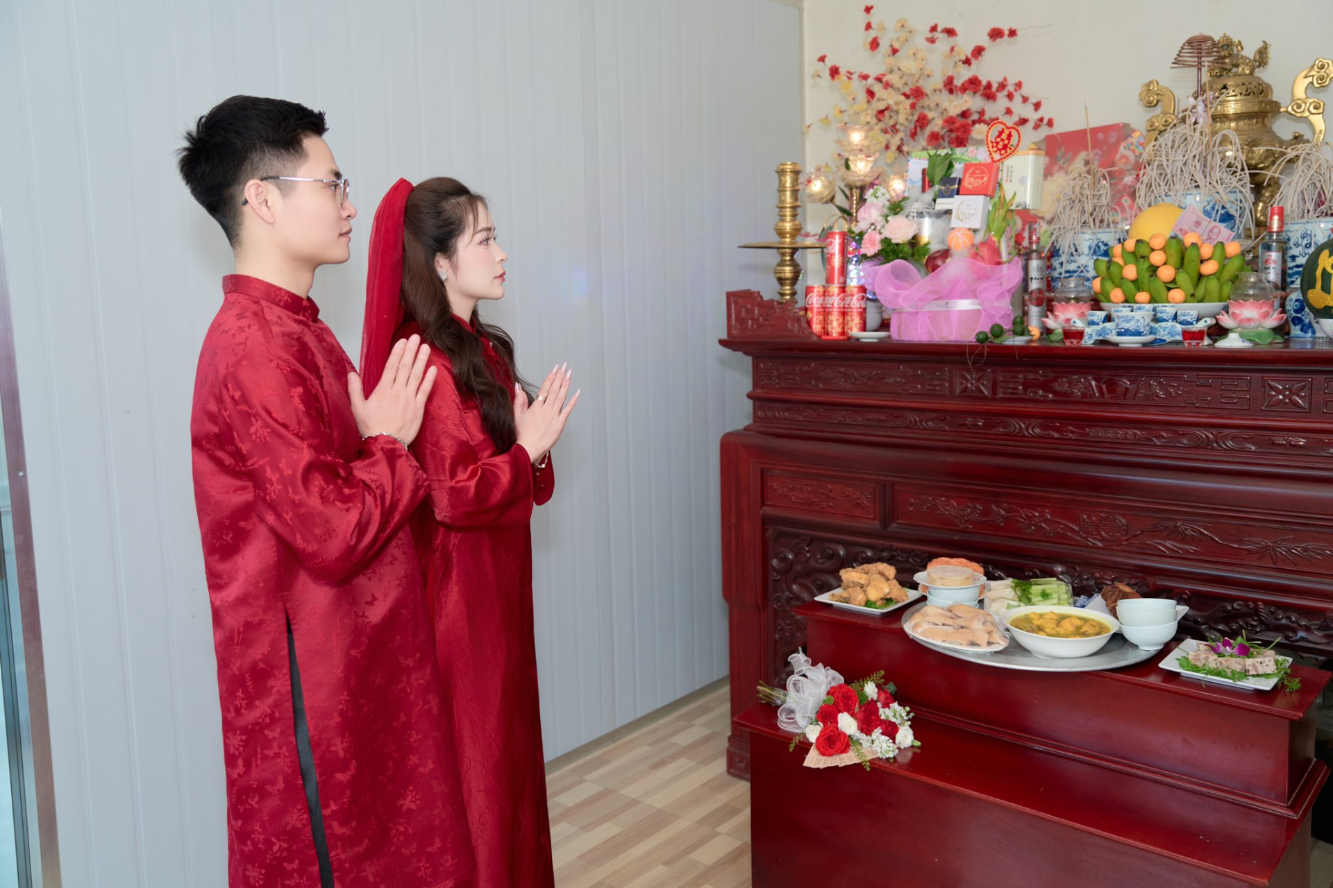 Anh Hữu Quảng và vợ trong lễ gia tiên. Hình ảnh hoa quả đặt phía nhà chị H.A. được bày biện trên ban thờ. 