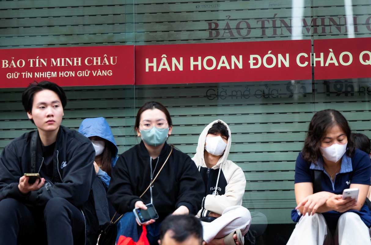 Nhiều người tranh thủ chợp mắt hoặc ngồi lướt điện thoại chờ đến lượt giao dịch