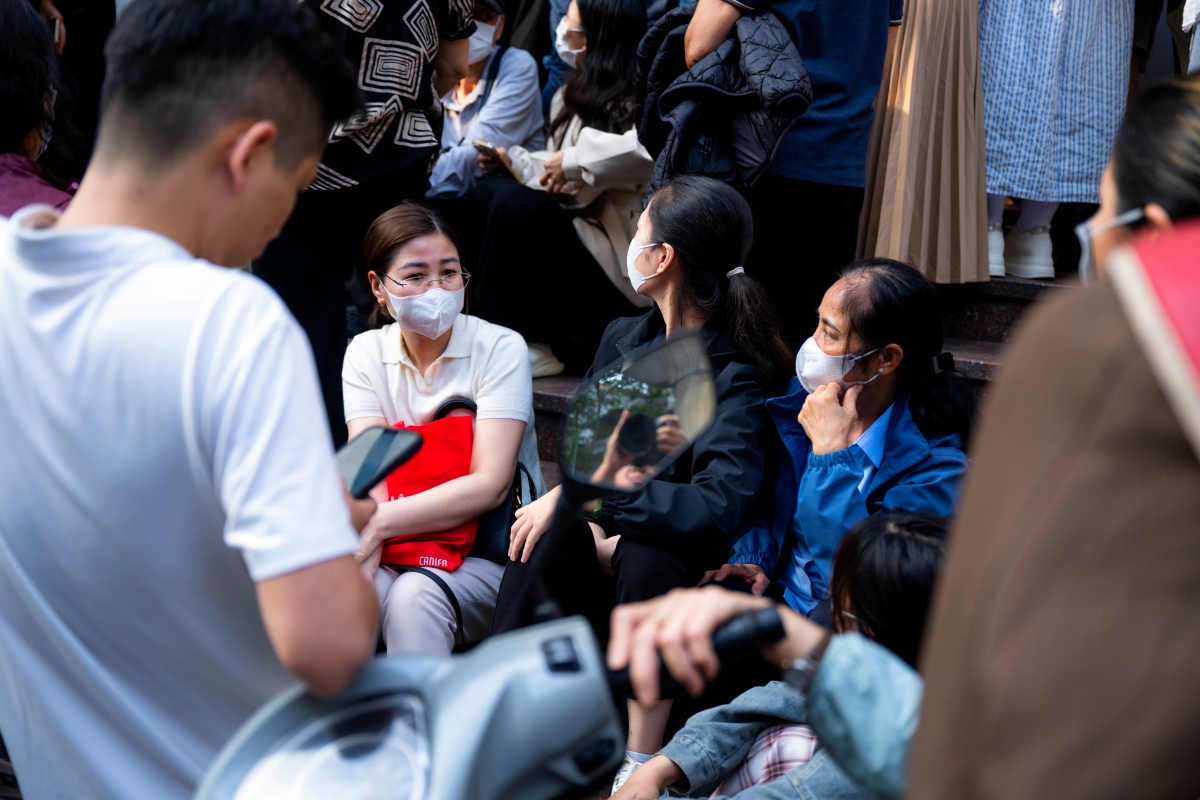 Nhiều người sốt ruột liên tục quan sát xung quanh chờ đợi lấy số để vào giao dịch