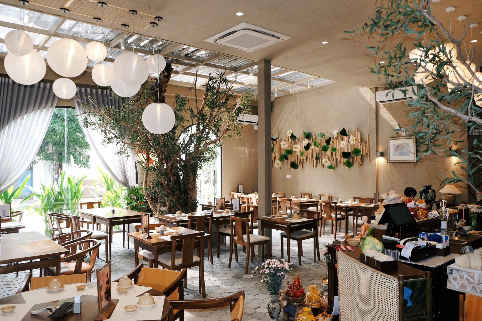 Không gian quán được thiết kế để đón ánh sáng tự nhiên ngoài trời, xen kẽ là những tán cây, tạo cảm giác thoải mái cho khách hàng