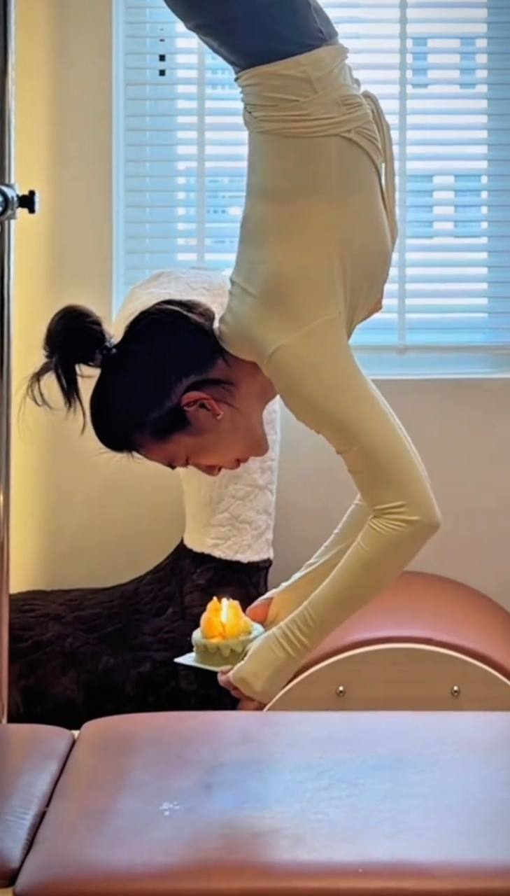 Nữ diễn viên giữ thăng bằng để thổi nến. 