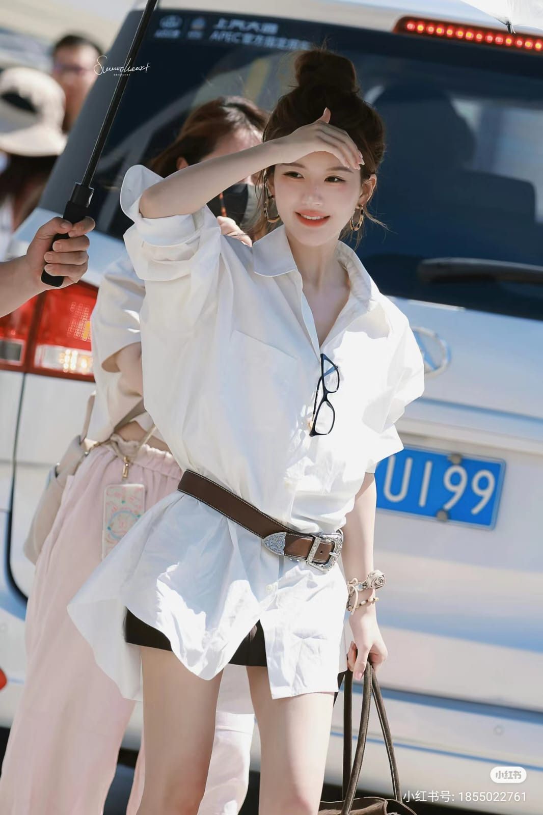 Vẫn là sơ mi trắng, người đẹp 9x chọn dáng oversized form dài, chất vải mềm và hơi nhăn tự nhiên để tạo cảm giác thoải mái, không quá chỉn chu kiểu công sở. Thay vì mặc theo cách thông thường, nữ diễn viên dùng thắt lưng bản vừa màu nâu để chiết nhẹ eo, biến chiếc sơ mi rộng thành outfit có tỷ lệ rõ ràng và tạo hiệu ứng chân dài hơn. Form áo rộng, tay áo xắn cao và phần cổ mở nhẹ khiến tổng thể vẫn giữ được sự mềm mại, không bị quá sexy dù diện short siêu ngắn bên trong. Đây cũng là kiểu mặc áo sơ mi trắng rất phổ biến của hội cool girl vì vừa trẻ trung vừa tạo cảm giác sang chảnh tự nhiên.