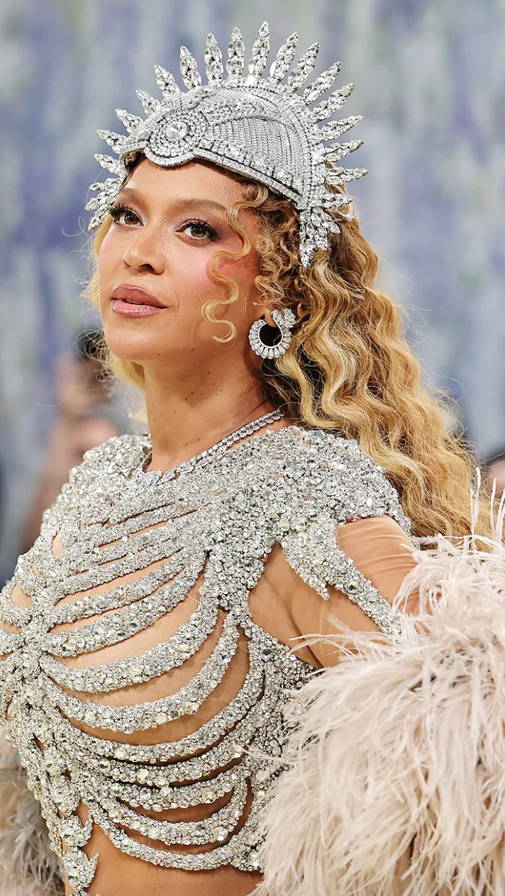   Phần khuyên tai cũng không hề “làm nền”. Beyoncé lựa chọn đeo hai cặp khuyên cùng lúc, một kiểu layering hiếm thấy ở trang sức cao cấp. Tổng thể bao gồm một cặp dáng semi-hoop với khoảng 13.45 carat kim cương, và một cặp khác dạng dáng quạt khoảng 3.77 carat, tất cả đều chế tác từ vàng trắng 18k và kim cương pavé.  