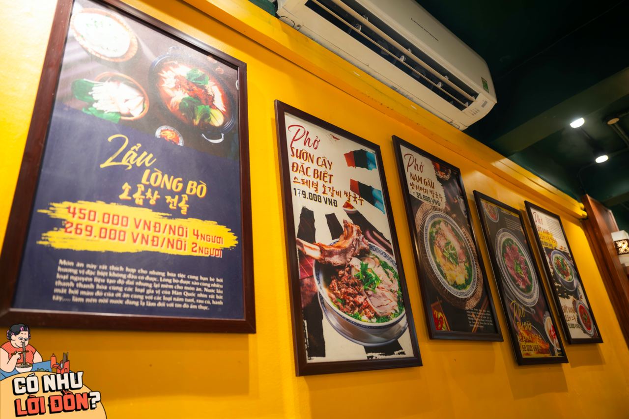  Menu treo trên tường được in rõ ràng, có hình minh họa hấp dẫn và giá niêm yết để khách dễ dàng lựa chọn